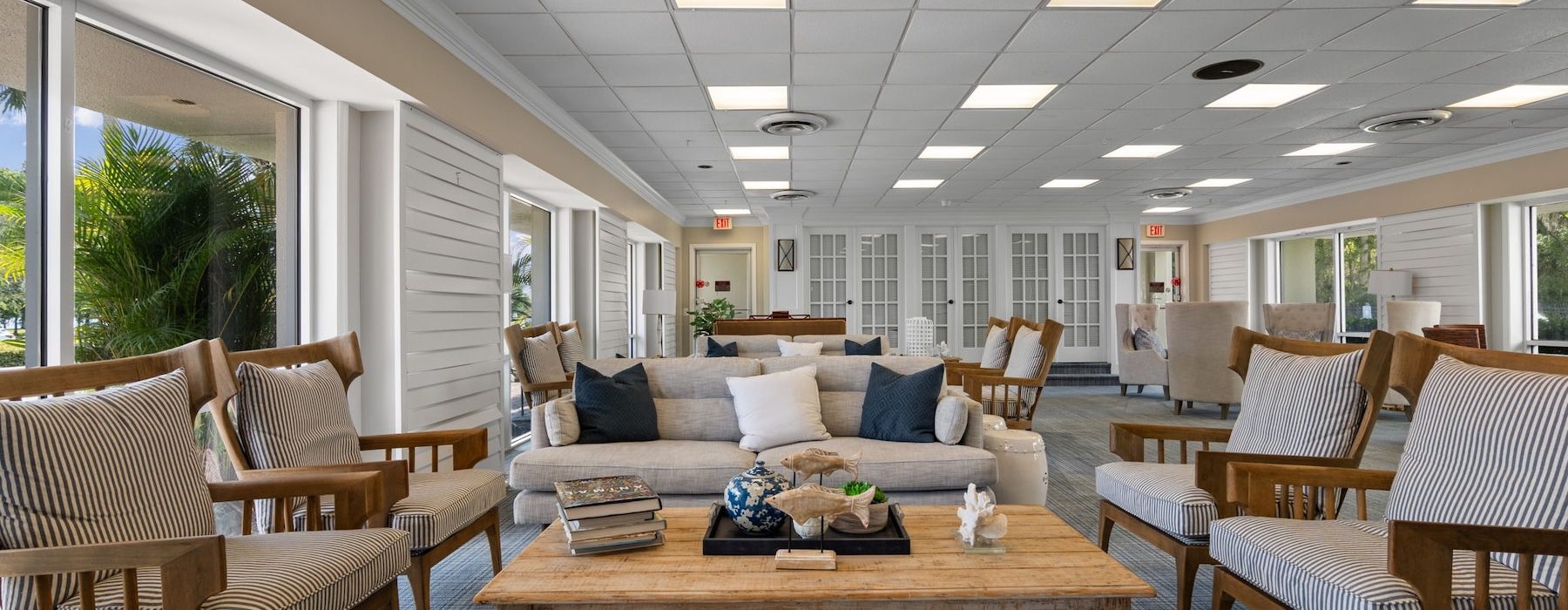 a room with a coffee table surrounded by couches and chairs