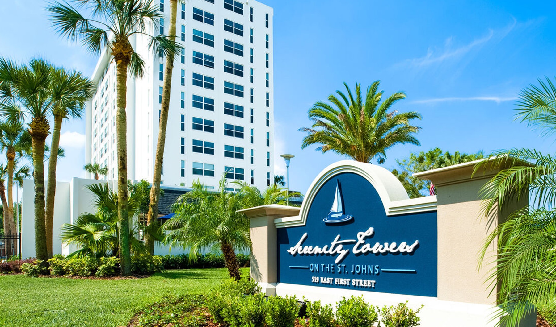 aerial view of a building with the sky and body of water in the background 